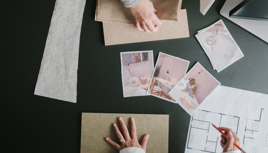 Cost-Plus vs. Fixed-Price Building: What Homeowners Should Know Designer reviewing custom home floor plans with tile and flooring samples during the interior design and selections process.